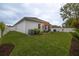 Expansive backyard with a privacy fence, lush lawn, patio area, and tropical foliage, creating a serene outdoor space at 9033 Cape Cod Rd, Deland, FL 32724