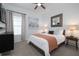 Cozy bedroom featuring neutral tones, a comfortable bed, stylish furniture, accent lighting, and a decorative cityscape art piece at 9033 Cape Cod Rd, Deland, FL 32724