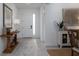 Bright foyer with wood-look tile flooring, white walls, console table, and stylish decor at 9033 Cape Cod Rd, Deland, FL 32724