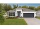 Charming single-story home featuring a manicured lawn, brick driveway, and an attached two-car garage at 9033 Cape Cod Rd, Deland, FL 32724