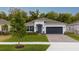 Charming single-Gathering home features a well-manicured lawn, gray door, and two-car garage at 9033 Cape Cod Rd, Deland, FL 32724