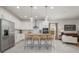 Open-concept kitchen with stainless steel appliances, white cabinets, and seating at the center island at 9033 Cape Cod Rd, Deland, FL 32724