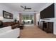 Cozy living room with a leather sofa, a wooden ceiling fan, and access to the screened patio at 9033 Cape Cod Rd, Deland, FL 32724