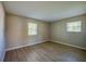 Bright bedroom with wood-look floors and two sunny windows at 912 Tree Garden Dr, Port Orange, FL 32127