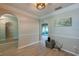 This living area has an arched doorway to a room with sliding glass doors, wood-look floors, and natural light at 912 Tree Garden Dr, Port Orange, FL 32127