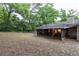 Exterior view of the house from the backyard, featuring a screened-in patio and lawn leading into a forested area at 929 Torchwood Dr, Deland, FL 32724