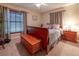 Cozy bedroom featuring a wooden chest at the foot of the bed, complemented by a window with blinds and wooden frames at 929 Torchwood Dr, Deland, FL 32724
