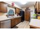 View of kitchen boasting wooden cabinets, stainless steel dishwasher, black fridge, and light-colored wood-look floors at 929 Torchwood Dr, Deland, FL 32724