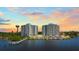 Stunning aerial view of two high-rise condos, featuring a pool, a pier, and gorgeous sunset at 935 N Halifax Ave # 309, Daytona Beach, FL 32118