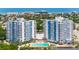 An aerial view of two condo buildings featuring a pool and water views of the ocean at 935 N Halifax Ave # 309, Daytona Beach, FL 32118