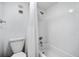 Bright, all-white bathroom with a shower and bathtub combination, and tiled walls at 935 N Halifax Ave # 309, Daytona Beach, FL 32118