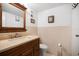 Cozy bathroom featuring a wooden vanity, large mirror, and soft pink tile accents at 935 N Halifax Ave # 309, Daytona Beach, FL 32118