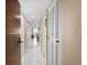 Bright hallway with white tile flooring leads to a dining area, featuring plenty of storage at 935 N Halifax Ave # 309, Daytona Beach, FL 32118