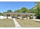 Inviting single-story home featuring a manicured lawn and convenient covered parking at 10 Lilac Dr, Debary, FL 32713