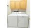 Bright laundry room features a white washer, dryer, and overhead cabinets for convenient storage at 1222 Brandy Lake View Cir, Winter Garden, FL 34787