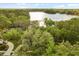 Scenic aerial view of lake house surrounded by lush greenery at 1227 Baypoint Ct, Longwood, FL 32750