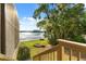 View of the backyard with a lake, featuring lush greenery and a wooden staircase from the home at 1227 Baypoint Ct, Longwood, FL 32750