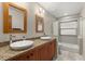 Bright bathroom featuring double sinks, wood cabinetry, granite counters, and tub with shower at 1227 Baypoint Ct, Longwood, FL 32750
