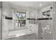Bright bathroom with marble tile, large soaking tub, and a glass shower enclosure at 1227 Baypoint Ct, Longwood, FL 32750