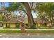 Charming yellow house with lush landscaping and a brick mailbox, shaded by mature trees draped with Spanish moss at 1227 Baypoint Ct, Longwood, FL 32750
