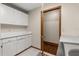 Laundry room featuring white cabinets, folding counter, tile floors, and access to a walk-in closet at 1227 Baypoint Ct, Longwood, FL 32750