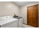 Laundry room showcasing washer, dryer, tile flooring, and a convenient wood door at 1227 Baypoint Ct, Longwood, FL 32750
