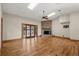 An open living room featuring hardwood floors, skylights and a stone fireplace, adjacent to sliding glass doors at 1227 Baypoint Ct, Longwood, FL 32750