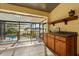 A covered patio featuring tile flooring, a view of the screened in pool, lush backyard and lake at 1227 Baypoint Ct, Longwood, FL 32750