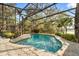 A screened-in pool with a view of the lake and lush greenery that creates a backyard oasis at 1227 Baypoint Ct, Longwood, FL 32750