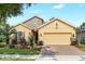 Inviting single-story home with a well-manicured lawn, stone accents, and a two-car garage at 1386 Hazeldene Mnr, Deland, FL 32724