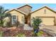 Charming home exterior featuring a stone accent wall, lush landscaping, and a brick driveway at 1386 Hazeldene Mnr, Deland, FL 32724