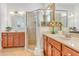 Elegant bathroom with double sinks, wood cabinets, and a glass shower at 1684 Victoria Gardens Dr, Deland, FL 32724