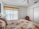 Bright bedroom with ceiling fan, closet, and window with decorative curtains and blind at 1711 Francisco St, The Villages, FL 32159
