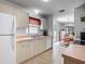 Bright kitchen featuring white cabinets, tiled floor, and a window looking out to the backyard at 1711 Francisco St, The Villages, FL 32159