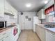 Functional kitchen with white cabinets, tiled floor, and essential appliances ready for Gathering meals at 1711 Francisco St, The Villages, FL 32159