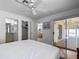 View of main bedroom with ceiling fan, ensuite bathroom, walk-in closet, and screened-in patio access at 1711 Francisco St, The Villages, FL 32159