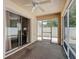 Enclosed patio featuring a ceiling fan, sliding glass doors, and screen door access to the outside at 1711 Francisco St, The Villages, FL 32159