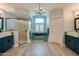 This bathroom features teal cabinetry, double sinks, tile flooring, and a tub with a window at 1792 Arash Cir, Port Orange, FL 32128