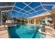 Inviting screened-in pool with a spillover spa, patio, and beautifully landscaped surroundings at 1792 Arash Cir, Port Orange, FL 32128