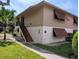 Exterior view of condo with brown shutters, manicured bushes, and palm tree at 190 Hickory Woods Ct # 15C, Deltona, FL 32725