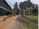 Exterior view of the community grounds with a walkway, mature trees, and landscaping features at 190 Hickory Woods Ct # 15C, Deltona, FL 32725