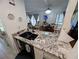 The kitchen has granite counters, stainless sink and black fixtures with an open view of the dining and living areas at 190 Hickory Woods Ct # 15C, Deltona, FL 32725
