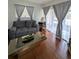 Bright living room with hardwood floors, grey sofa, and natural light from large windows at 190 Hickory Woods Ct # 15C, Deltona, FL 32725