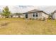 Spacious backyard with lush green grass, a cozy patio area with chairs, and well-maintained landscaping for outdoor enjoyment at 207 Pitching Wedge Dr, Daytona Beach, FL 32124