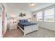 Bright bedroom with a white bed frame, coastal decor, plush carpet, and natural light from two large windows at 207 Pitching Wedge Dr, Daytona Beach, FL 32124