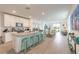 Modern kitchen with white cabinetry, granite island with seating, stainless steel appliances, and open to the living area at 207 Pitching Wedge Dr, Daytona Beach, FL 32124