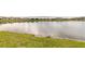 Panoramic view of a serene lake surrounded by lush greenery and neighboring houses in the distance at 207 Pitching Wedge Dr, Daytona Beach, FL 32124