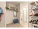 Spacious walk-in closet with shelves, mirror, ottoman, and access to a bathroom featuring tiled floors and a glass shower door at 207 Pitching Wedge Dr, Daytona Beach, FL 32124