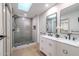 Modern bathroom featuring a walk-in shower with decorative tile, double sink vanity, and a skylight at 210 Sage Brush Trl, Ormond Beach, FL 32174