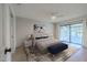 Staged bedroom with wood-look flooring, ceiling fan, and sliding door access to the outdoor patio at 210 Sage Brush Trl, Ormond Beach, FL 32174